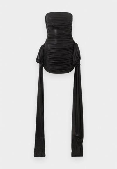 Μίνι μαύρο φόρεμα χωρίς τιράντες με σούρες και μακριά, ρέουσα υφασμάτινη επέκταση που κρέμεται από κάθε πλευρά στο ύψος των γοφών.