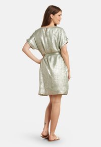 Short, light green metallic dress with a relaxed fit, short sleeves, and a belted waist. Back features a keyhole opening.