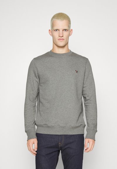 Grå sweatshirt med lange ærmer og rund halsudskæring, med et lille broderet logo på brystet. Materialet ser blødt ud.