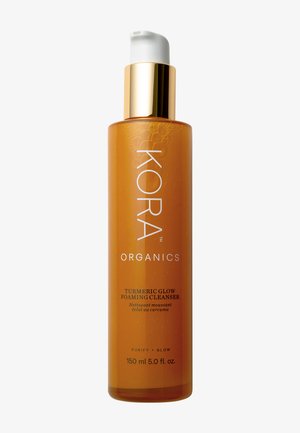 Turmeric Glow Foaming Cleanser in een transparante amberkleurige fles met een witte pomp en gouden dop. 150 ml, bevat de tekst "PURIFY + GLOW".