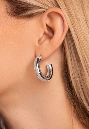 Boucle d'oreille en argent avec un design élégant et courbé. Finition polie et une forme unique et asymétrique.