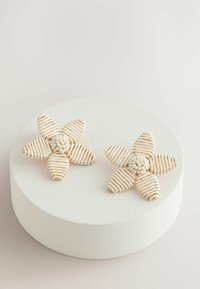 Beaded floral earrings featuring cream and gold stripes, shaped like flowers with textured petals and a cluster of white beads at the center.