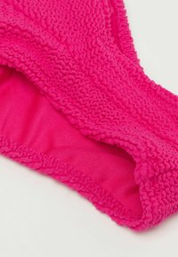 Bas de bikini rose vif avec des bords texturés et froncés, et une doublure intérieure lisse, présentant un motif ondulé le long de la taille.