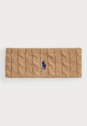 Un serre-tête en tricot marron fabriqué en tissu doux, avec un petit logo brodé bleu. Design texturé avec des motifs en relief sur toute la surface.