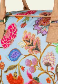 Handtas met bloemenpatroon in lichtblauw met levendige roze, paarse en groene ontwerpen. Voorzien van tan leren handvatten en een gouden merklogo.