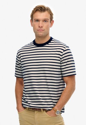 Camiseta de rayas en azul marino y blanco con mangas cortas y un escote redondo. Fabricada en tela suave, presenta un ribete liso en azul marino.