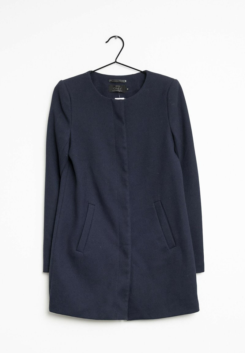 Mörkblå rock med rund halsringning, två sidofickor och rak skärning. Tillverkad av textil med struktur, hängande på en galge.