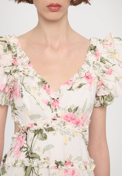 Bloemrijke jurk met een V-hals, pofmouwen, ingewikkelde ruffles, roze en groene patronen op een lichte achtergrond, met kantaccenten.