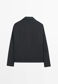 Maglietta nera a maniche lunghe con colletto, texture liscia e taglio dritto. Nessun motivo o dettagli in metallo visibili.