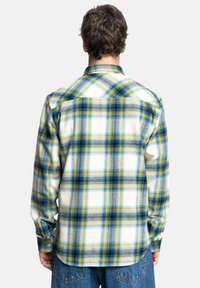 Koszula w kratkę z długim rękawem, w mixie odcieni niebieskiego, żółtego i zielonego na białym tle. Wykonana z miękkiego materiału z zapinanymi mankietami.