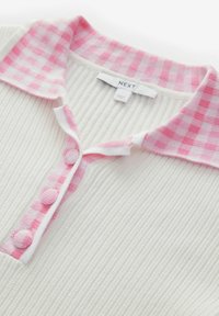 Weißes geripptes Strickoberteil mit einem rosa-weißen Vichykaro-Kragen. Mit drei rosa Knopfakzenten am Ausschnitt. Markenlabel sichtbar.