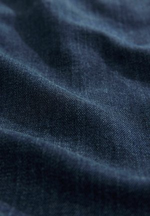 Tessuto in denim blu scuro con una sottile trama e una naturale elasticità, che presenta una superficie liscia con lievi riflessi di luce.