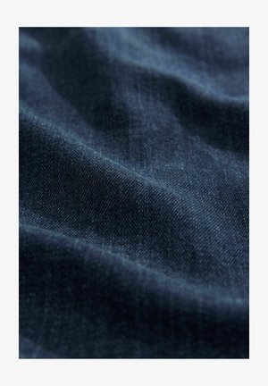 Mørkeblå denimstof med subtil tekstur og naturlig stræk, der viser en jævn overflade med lette lysrefleksioner.