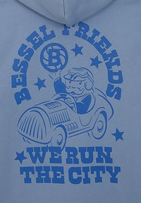 Sudadera de color azul claro con un gráfico azul de un personaje de dibujos animados en un coche vintage, sosteniendo una pelota, con el texto "BESSEL FRIENDS WE RUN THE CITY."