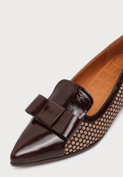 Chaussure plate pour femme à bout pointu avec nœud et bout en cuir verni marron foncé, et côtés en tissu marron à pois texturés.
