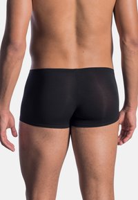 Black shorts made of soft, stretch fabric. Features a seamless waistband, fitted cut, and smooth texture. Suitable for active wear.
