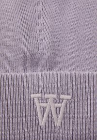 Berretto a maglia lavanda con texture a coste, caratterizzato da una lettera 'W' bianca ricamata sul davanti. Primo piano dei dettagli della corona e del bordo.