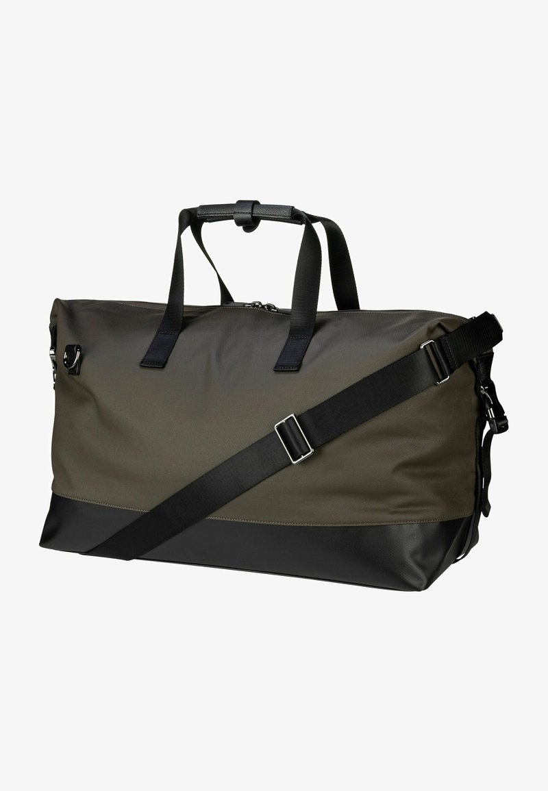 Olivgrön duffelväska med svarta detaljer, tillverkad av ett slitstarkt tyg. Har två handtag, justerbar axelrem och dragkedjestängning.