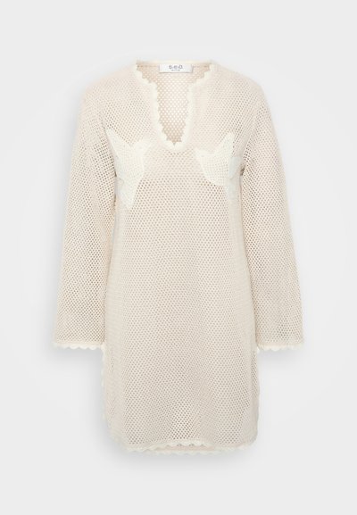 Krämfärgad stickad tunika med långa ärmar, V-ringning, vågiga kanter och broderade fågelmotiven på framsidan.