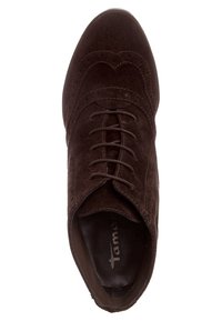 Scarpa in suede marrone con lacci, punta arrotondata, cuciture decorative e una foderatura interna liscia. Presenta un design minimalista.