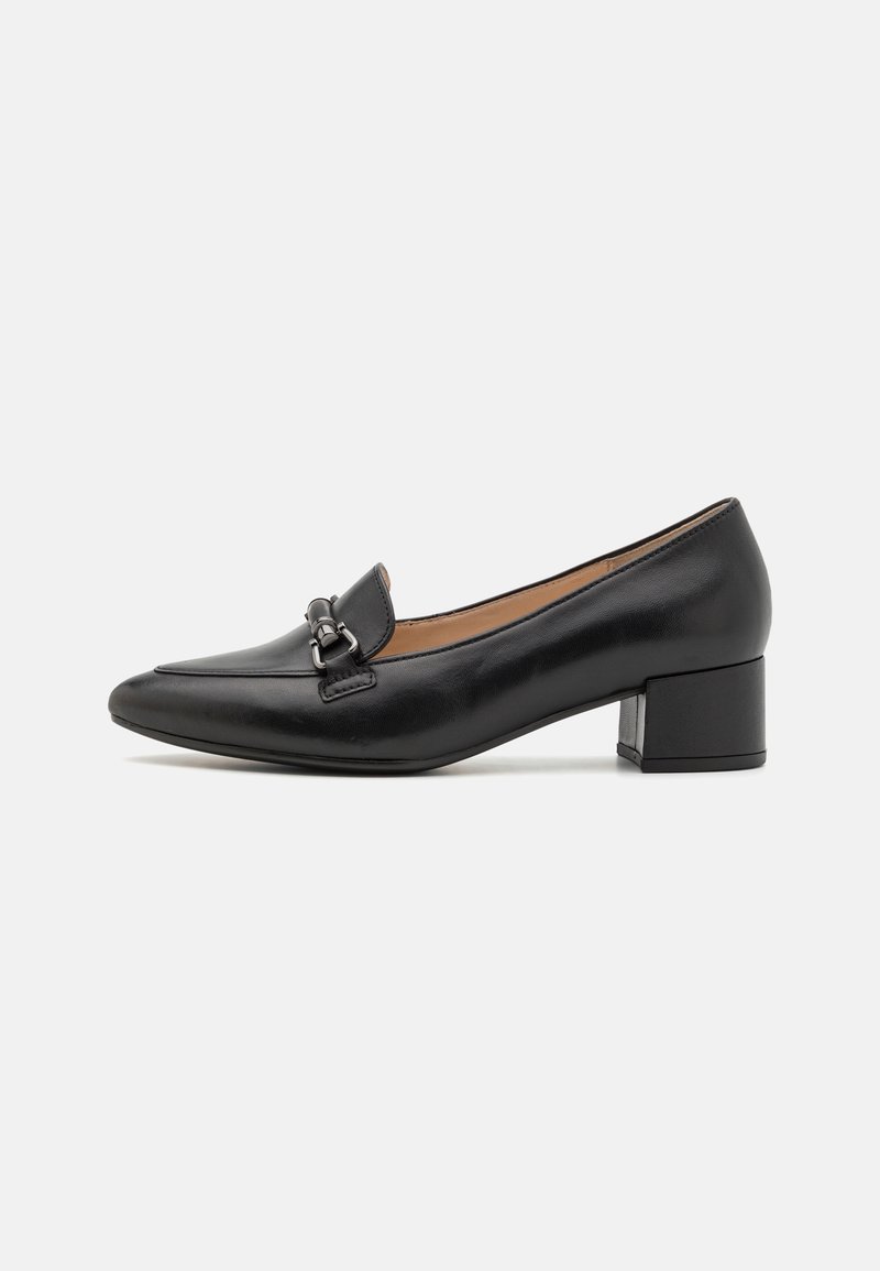 Mocassin en cuir noir à talon moyen, bout pointu et détail mors argenté sur le dessus, sur fond blanc.