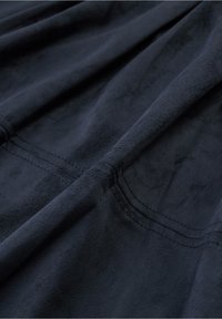 Temno modri material z mehko, usnjeno teksturo, ki vsebuje subtilne šive. Material se zdi gladek in rahlo sijoč.
