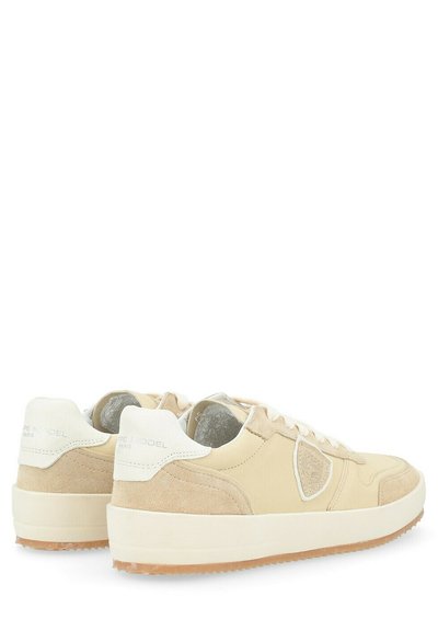 Sneaker beige con tomaia in suede e pelle testurizzata, punta rotonda, suola imbottita e un tallone bianco con marchio in rilievo.