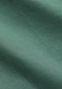 Sötétzöld textúrájú szövet, sima felülettel és látható szövésmintával; különféle textilipari alkalmazásokhoz alkalmas.