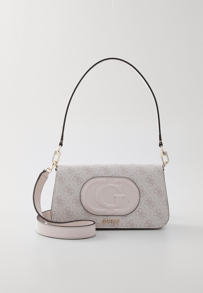 Laukku vaaleanpunaisesta materiaalista, jossa on logokoristeita, suorakulmainen muoto, irrotettava olkahihna ja kultaiset yksityiskohdat. Monogrammikuosi pinnalla.