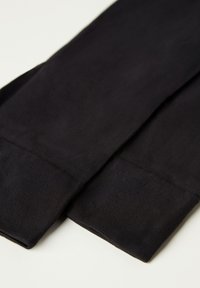 Leggings neri, elastici, con una superficie liscia e polsini alle caviglie testurizzati. Il materiale sembra morbido e leggero. Design semplice e senza cuciture.