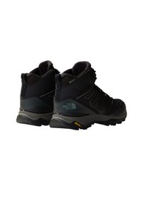 Czarne buty trekkingowe z siateczkowym i syntetycznym wierzchem, wyściółką w okolicy kostki, podeszwą Vibram oraz detalem z logo na pięcie. Trwała, solidna konstrukcja.