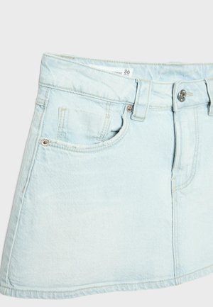 Světle modrá džínová mini sukně s předními knoflíky, poutky na pásek a dvěma předními kapsami na jednobarevném pozadí.