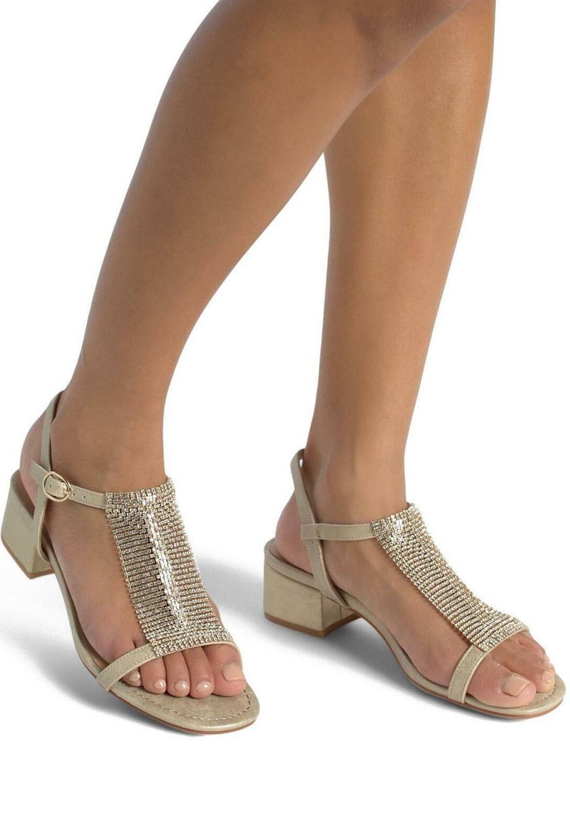 Sandalias con tacón en color beige y diseño de tira T, con una parte superior texturizada adornada con múltiples brillantes y un tacón cuadrado.