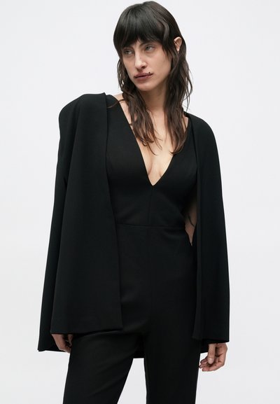 Black jumpsuit with a deep V-neck and wide sleeves. Smooth fabric, fitted design, accentuated waist, minimalistic style with clean lines.