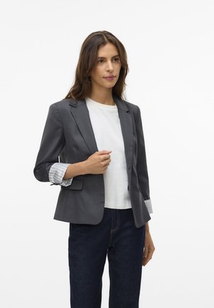 Gray blazer with a tailored cut, notch lapels, and striped cuff detail. Paired with a white t-shirt and dark denim jeans.