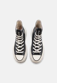 Zwarte hoge sneakers met witte veters. Bovenwerk van canvas, ronde neus met een crèmekleurige rubberen kap. Contrasterende stiksels en logo op de tong.