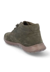 Zapato casual de ante oliva oscuro con cuello acolchado y suela de goma flexible marrón, mostrado desde un ángulo trasero derecho sobre fondo blanco.