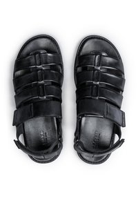 Sandali in pelle nera con molteplici cinturini orizzontali, chiusura alla caviglia regolabile e superficie liscia. Design largo per comfort e stabilità.