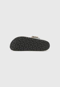 Black rubber shoe sole with a wavy tread pattern. Features a smooth, rounded shape with a slight rise at the heel and a flat bottom.
