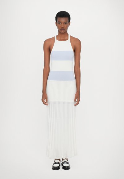 Knitted midi dress with light blue and white horizontal stripes, fitted bodice, and pleated white skirt. Paired with black and white shoes.