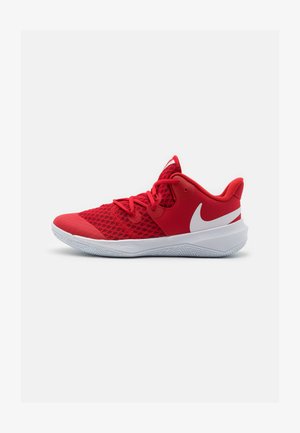 Rød atletiksko med overdel i netstof, rund tå og polstret krave. Har et hvidt swoosh-logo og en struktureret gummisål.