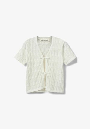 Valge lühikeste varrukatega kootud kardigan lipsuga kinnitustega, tekstureeritud mustriga, laineliste äärtega ja kaubamärgi sildiga kaeluse juures.