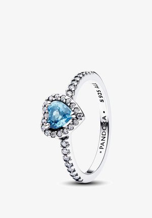 Bague en argent avec une pierre précieuse bleue en forme de cœur entourée de petites pierres claires, anneau détaillé et gravure "PANDORA S 925 ALE".