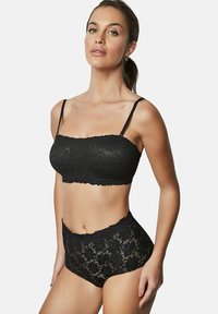 Zwarte kanten bralette met verstelbare banden, gecombineerd met hooggetailleerde kanten slipjes met scalloped randen en bloemenpatronen.