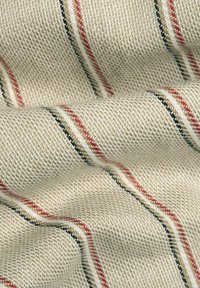 Beige geweven stof met een textuurpatroon; heeft rode en zwarte strepen die horizontaal lopen. De stof heeft een zachte, vallende uitstraling.