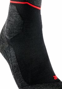 Calcetín negro con una raya roja, zona del talón texturizada y cuerpo liso con sutiles acentos en gris. Diseñado para comodidad y soporte.