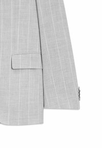 Hellgrauer Nadelstreifen-Anzugsjackenärmel mit Taschen-Detail und dunklen Knöpfen an der Manschette, dargestellt vor weißem Hintergrund.