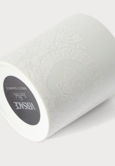 Mug en céramique blanche avec motif floral en relief et design tête de Méduse, marqué Versace au fond avec les détails du produit.