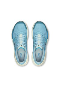 Baskets de sport bleu clair avec une tige en maille respirante, des lacets blancs contrastants et une semelle rembourrée, comportant un logo sur la languette et les côtés.