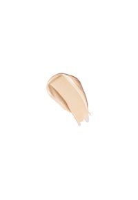 Muestra de maquillaje crema beige con una textura suave y ligeramente brillante, aplicada en forma curva sobre un fondo blanco.